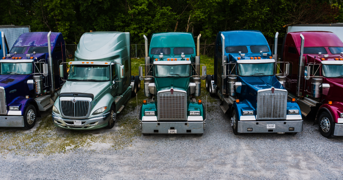 Row of semi-trucks parked in fleet yard | ECM maintenance for diesel trucks | Fleet manager diesel ECM repair